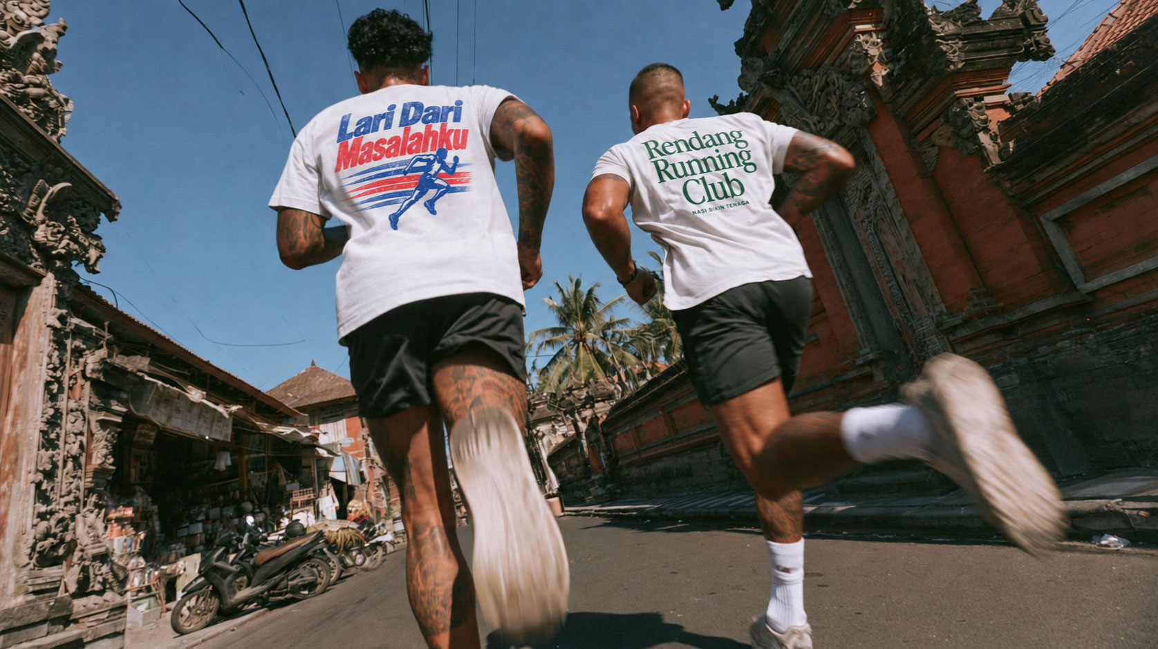 Two runners wearing Lari Dari Masalahku and Rendang Running Club tees on a Bali street